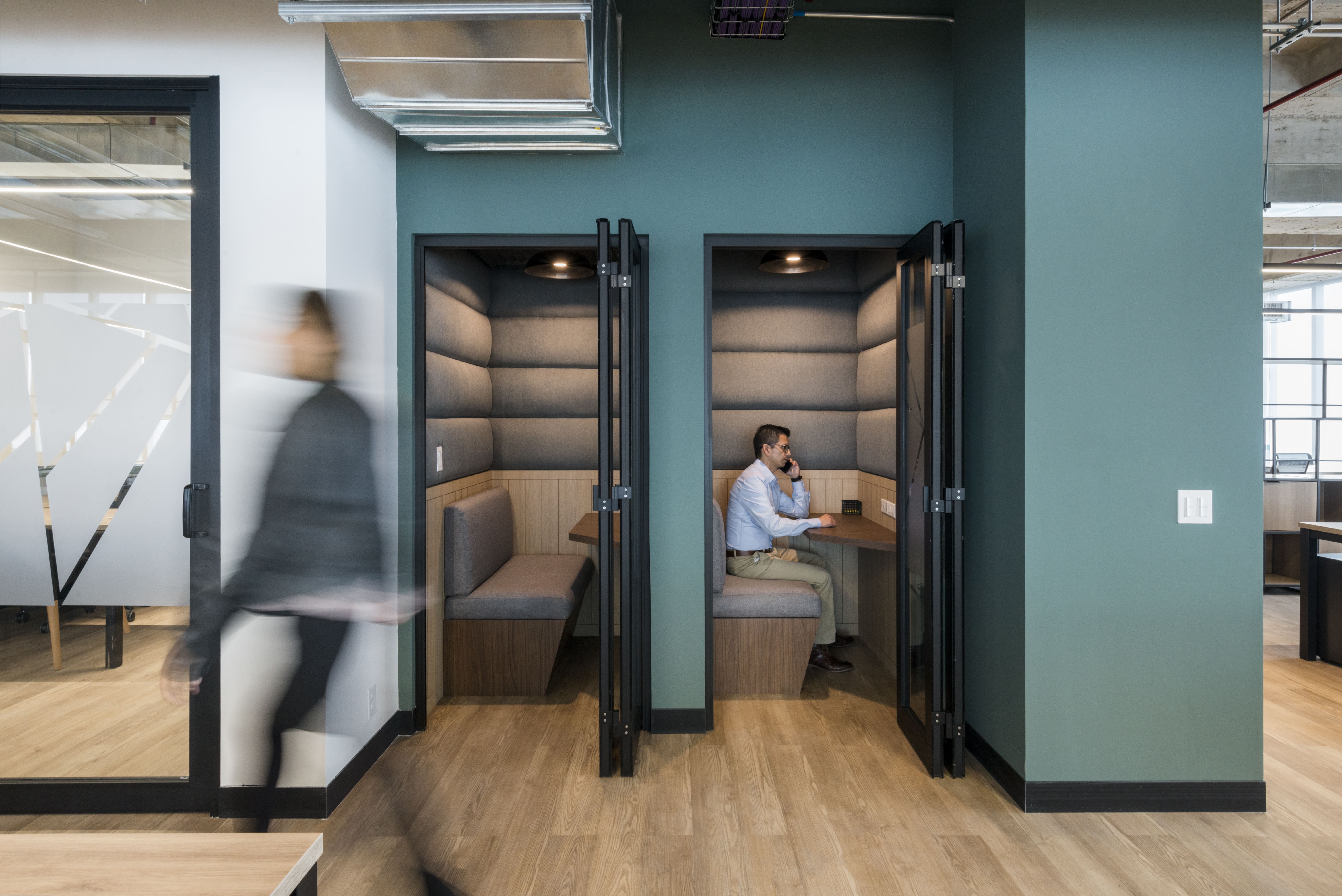 hombre llamando por telefono en una cabina de las oficinas privadas grandes de comunal
