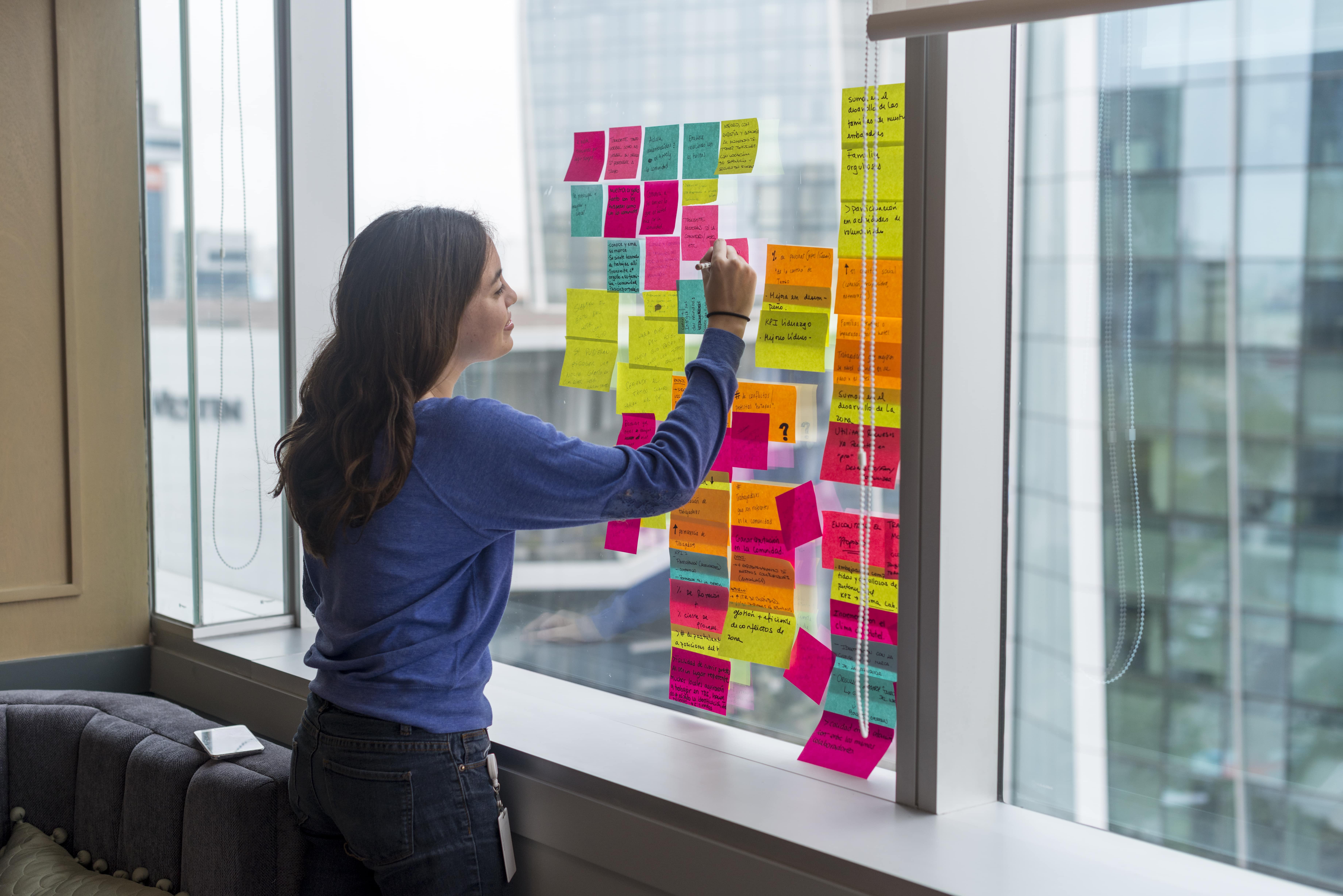 mujer haciendo brainstorming con post its