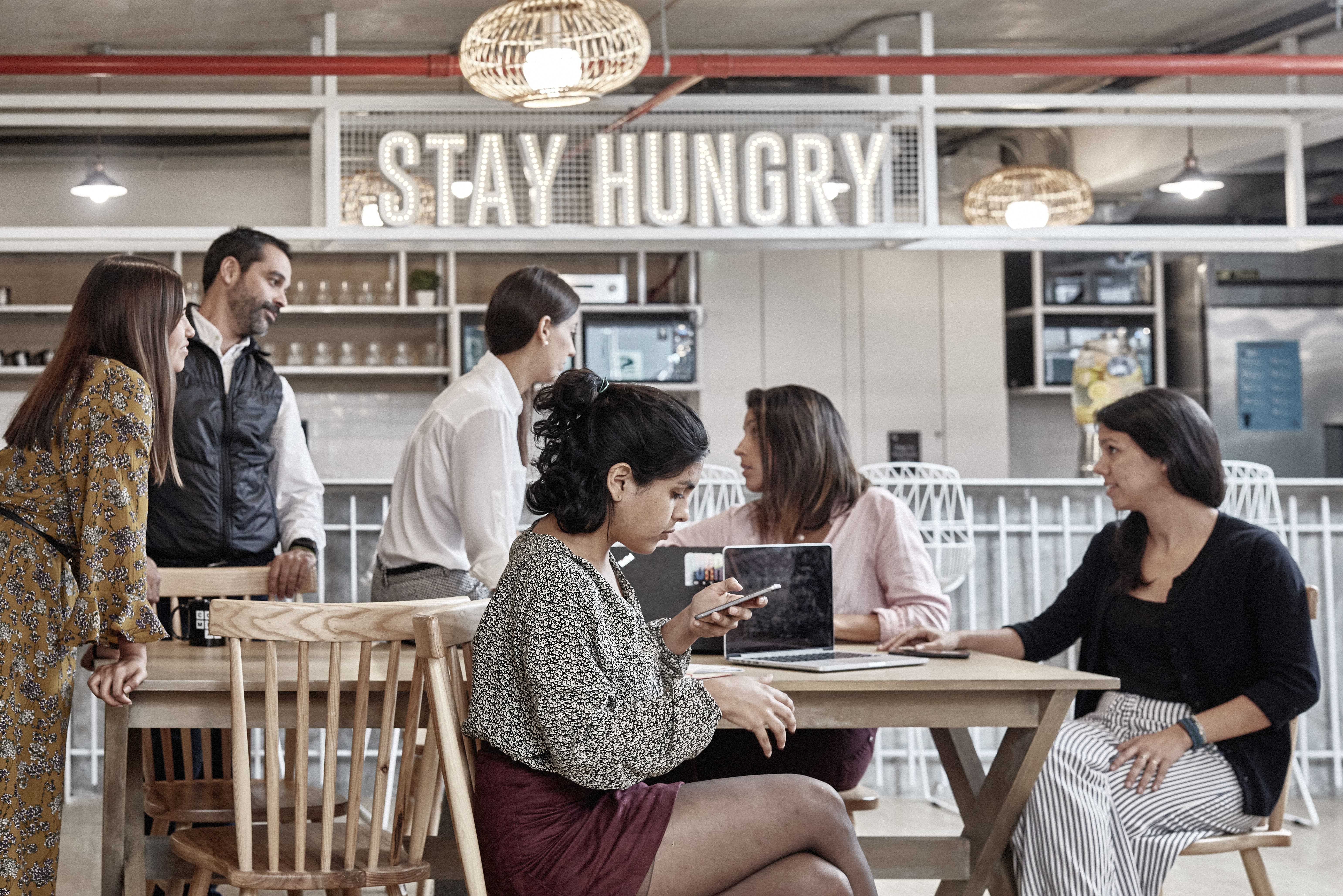 personas conversando en una cafeteria de un coworking